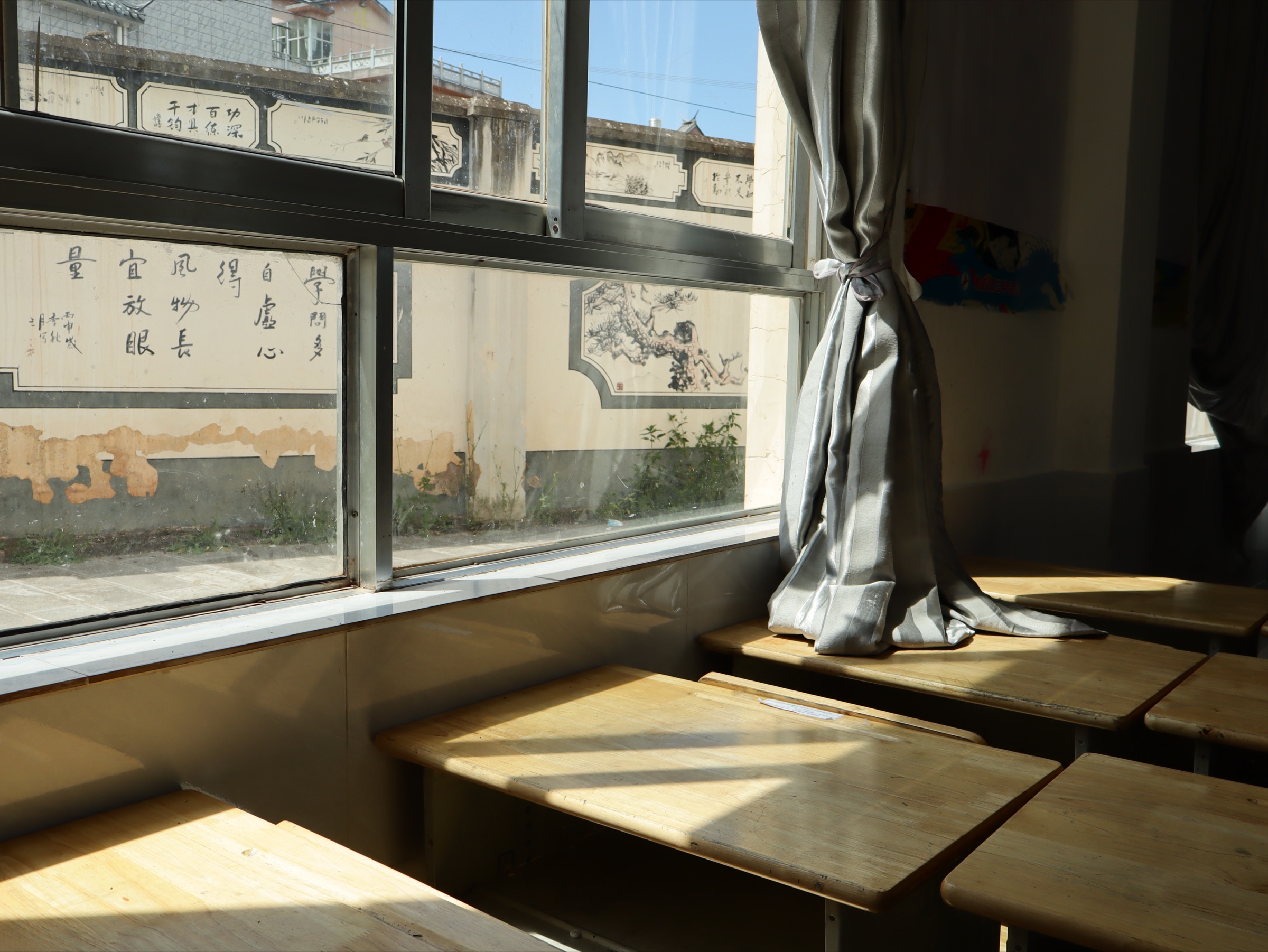 阳光穿过教室窗户,落在课桌上